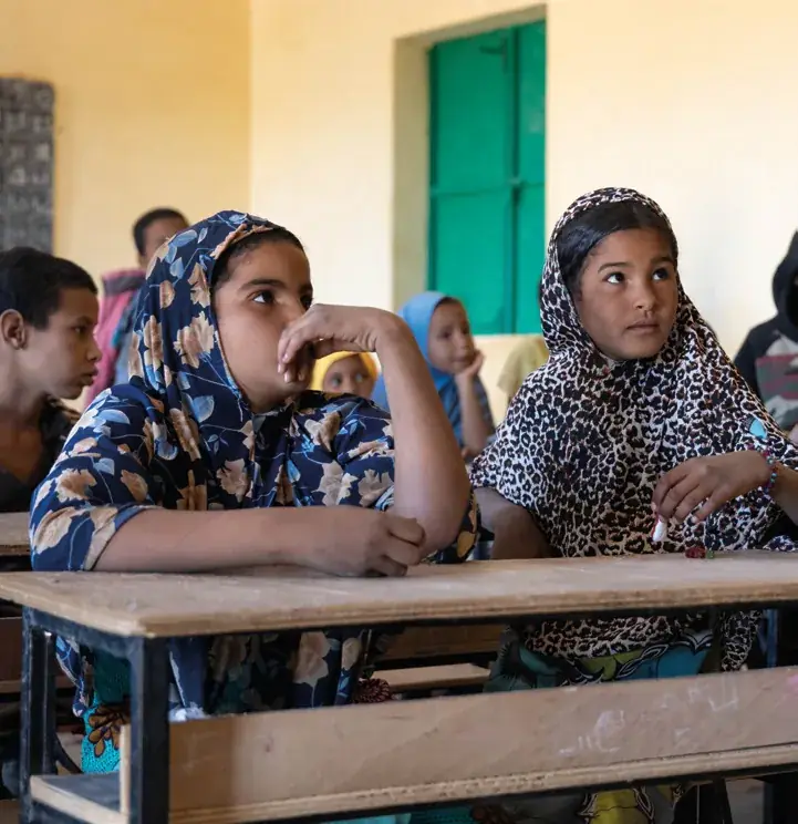Deux jeunes filles touarègues attentives dans une salle de classe d'une école construite par Les Puits du Désert