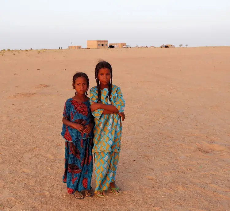 Deux jeunes filles devant un village sédentarisé dans la vallée de Tidène, région d'Agadez
